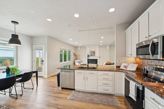 13994 S New Saddle Rd, Draper, UT 84020 - kitchen featuring appliances with stainless steel finishes, a peninsula, recessed lighting, light wood-style floors, and white cabinets
