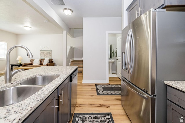 466 W 1595 N Unit 45-103, Logan, UT 84341 - kitchen with appliances with stainless steel finishes, a sink, light wood-type flooring, baseboards, and light stone counters