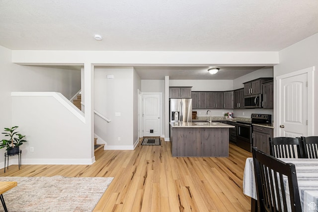 466 W 1595 N Unit 45-103, Logan, UT 84341 - kitchen with stainless steel appliances, light wood-style floors, a kitchen island with sink, and light countertops