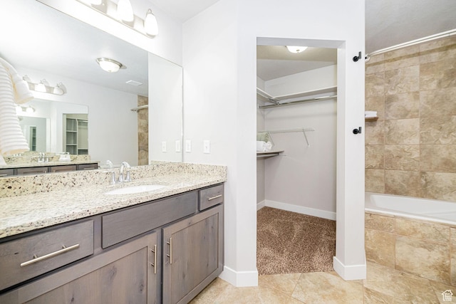 466 W 1595 N Unit 45-103, Logan, UT 84341 - full bath featuring tile patterned flooring, a walk in closet, vanity, baseboards, and tiled shower / bath combo