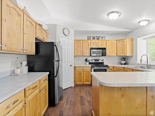 kitchen featuring appliances with stainless steel finishes, a sink, lofted ceiling, light brown cabinets, and light countertops