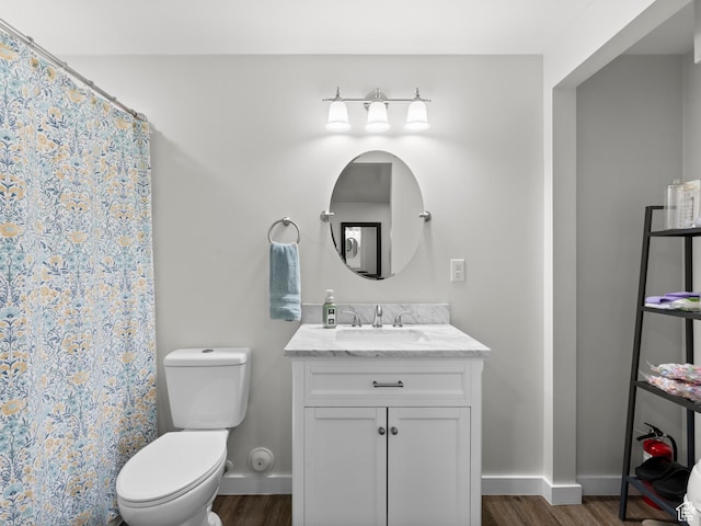 bathroom with wood finished floors, toilet, baseboards, vanity, and a shower with shower curtain