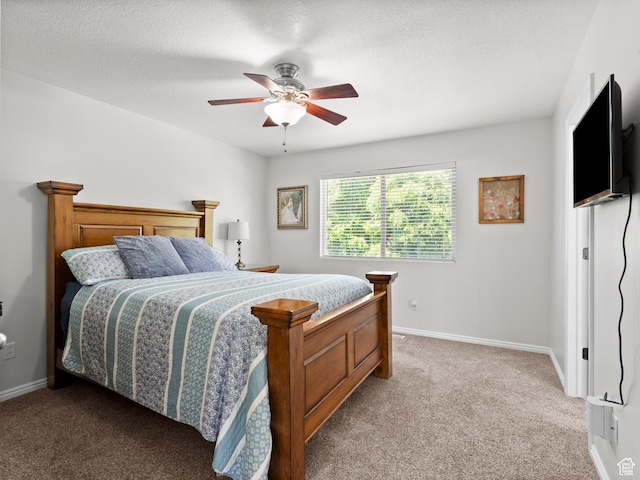 carpeted bedroom with a ceiling fan, baseboards, and a textured ceiling