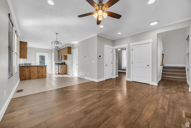 10342 S Millerton Dr, South Jordan, UT 84009 - unfurnished living room featuring ceiling fan, baseboards, stairway, hardwood / wood-style floors, and crown molding