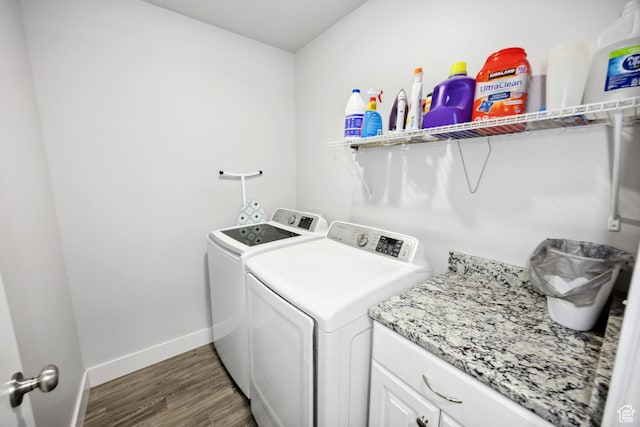 laundry area featuring washing machine and dryer, wood finished floors, and baseboards
