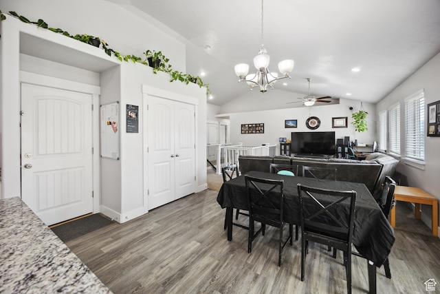 dining area with a ceiling fan, a chandelier, wood finished floors, lofted ceiling, and baseboards