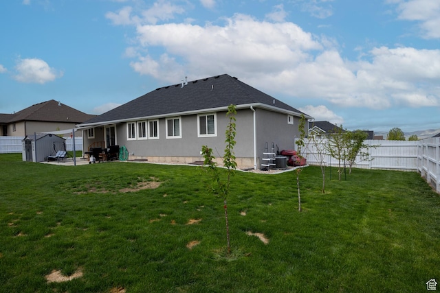 rear view of property with a patio, stucco siding, a storage shed, an outbuilding, and a shingled roof