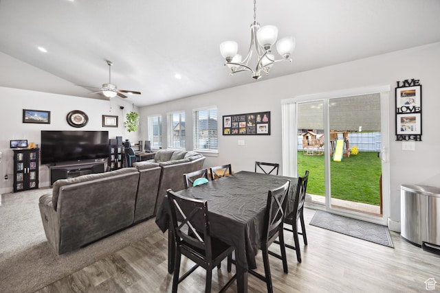 dining room featuring a chandelier, light wood-type flooring, ceiling fan, and vaulted ceiling