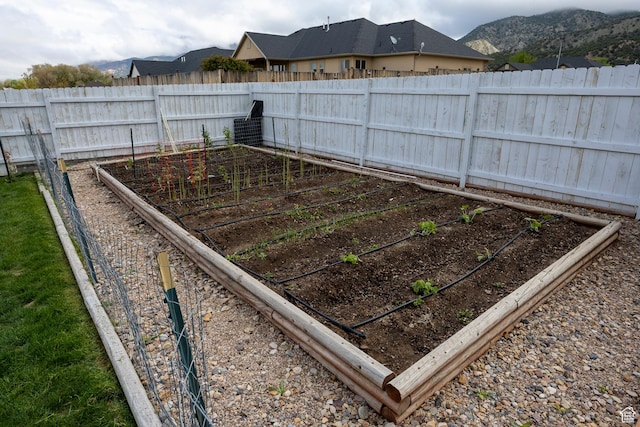fenced backyard with a garden and a mountain view