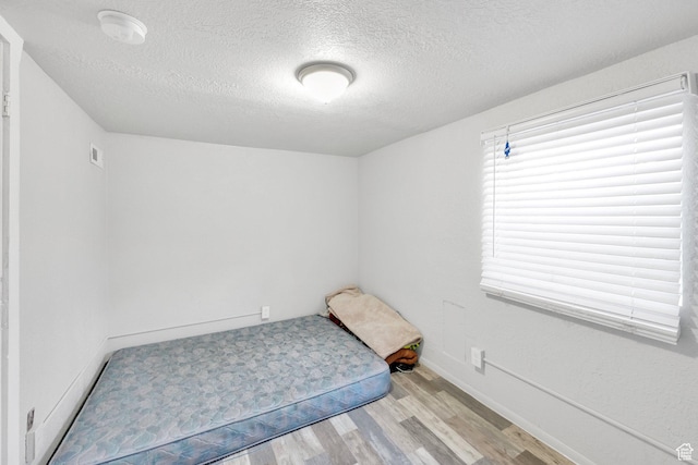 815 E 22nd St, Ogden, UT 84401 - unfurnished bedroom with wood finished floors, a textured ceiling, and baseboards
