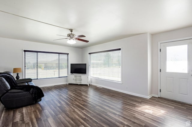 395 N 1st St, Tooele, UT 84074 - living room featuring dark wood-style floors, baseboards, ceiling fan, and plenty of natural light