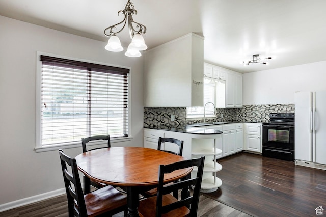 395 N 1st St, Tooele, UT 84074 - dining area featuring healthy amount of natural light, a chandelier, dark wood-style flooring, and baseboards