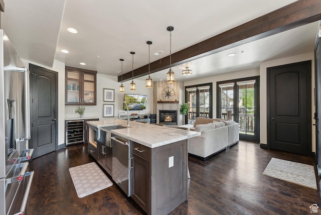 3029 Canyon Links Dr, Park City, UT 84098 - kitchen with beverage cooler, stainless steel appliances, beamed ceiling, a kitchen island with sink, and glass insert cabinets