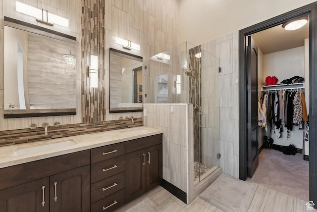 3029 Canyon Links Dr, Park City, UT 84098 - bathroom featuring a stall shower, double vanity, a walk in closet, and decorative backsplash
