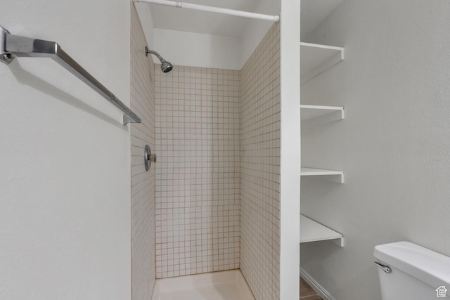 bathroom featuring a shower stall and toilet