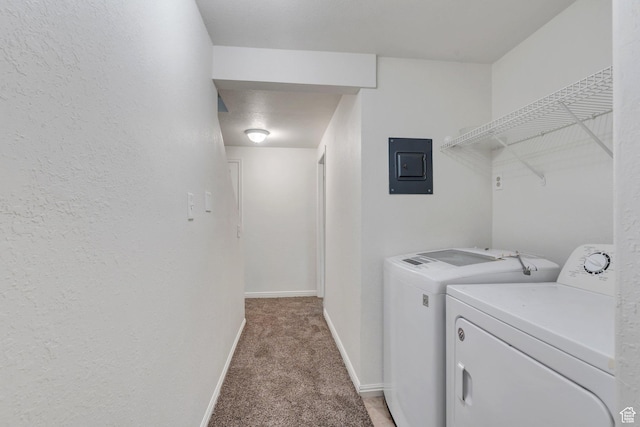 laundry area featuring electric panel, light carpet, separate washer and dryer, baseboards, and a textured wall