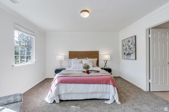 bedroom with ornamental molding, carpet floors, and baseboards