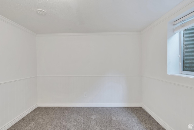 carpeted empty room with ornamental molding and baseboards