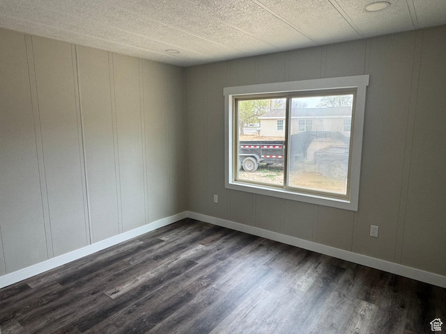 22 S 400 E, Myton, UT 84052 - unfurnished room with a decorative wall, dark wood finished floors, a textured ceiling, and baseboards
