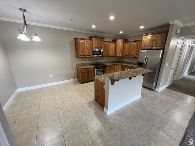 kitchen featuring appliances with stainless steel finishes, brown cabinets, dark stone countertops, a breakfast bar, and ornamental molding