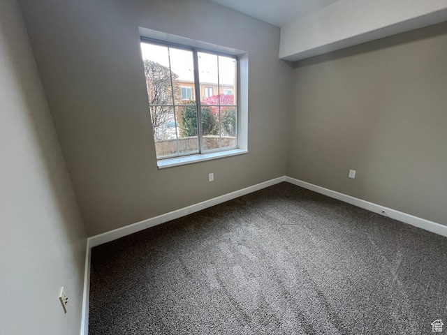 carpeted spare room featuring baseboards