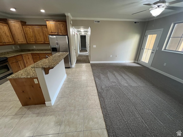 kitchen with stainless steel fridge, brown cabinetry, ornamental molding, electric range oven, and ceiling fan