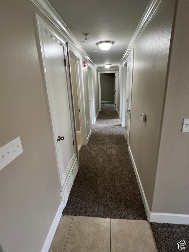 corridor featuring carpet flooring, baseboards, and crown molding