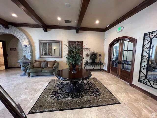 foyer featuring arched walkways, beam ceiling, french doors, ornamental molding, and baseboards