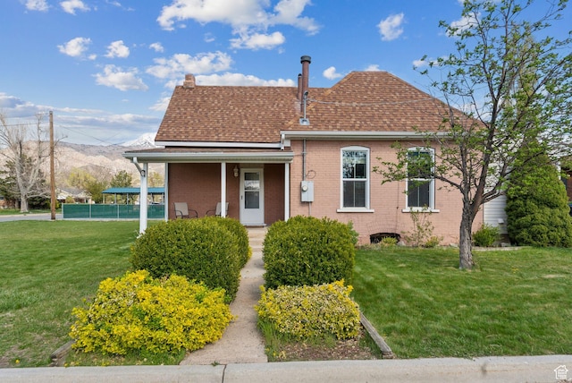 755 42nd St, South Ogden, UT 84403 - view of front of home featuring a front lawn, brick siding, a mountain view, a porch, and roof with shingles