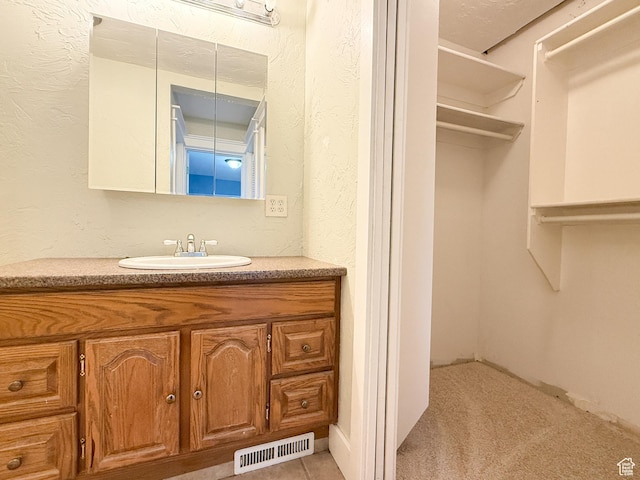 bathroom featuring vanity and a textured wall