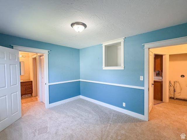 unfurnished bedroom featuring carpet flooring, baseboards, and a textured ceiling