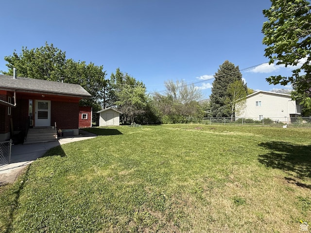 view of yard featuring a storage shed, entry steps, and an outdoor structure