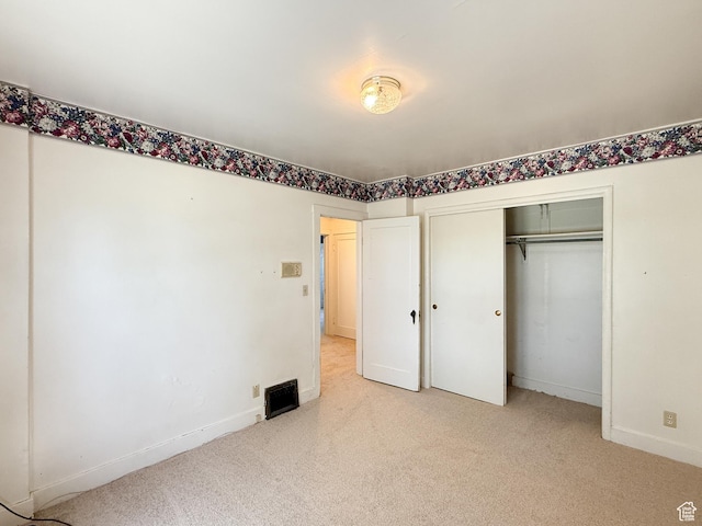 unfurnished bedroom with baseboards, carpet floors, and a closet