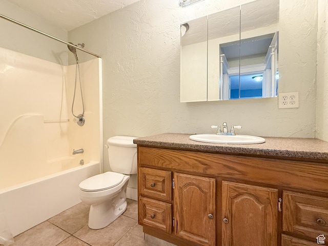 bathroom with a textured wall, tile patterned flooring, toilet, vanity, and  shower combination