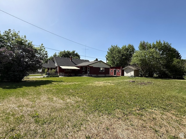 view of green lawn featuring a shed