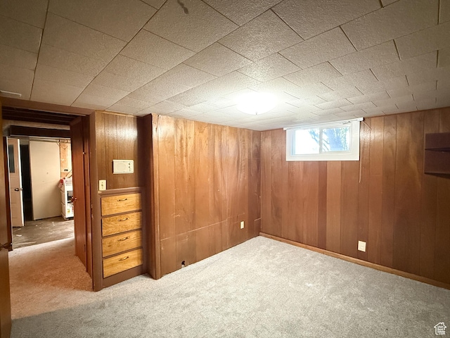 basement featuring carpet floors and wood walls