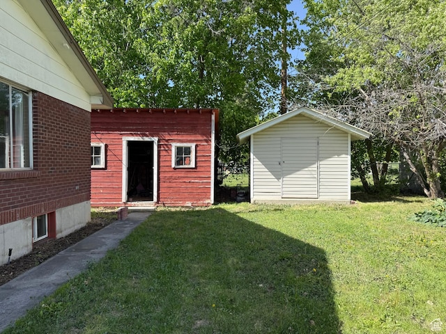 view of grassy yard with an outbuilding and a shed