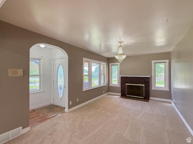 unfurnished living room featuring carpet, healthy amount of natural light, and baseboards