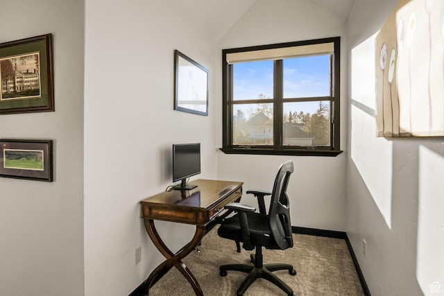 carpeted home office with lofted ceiling and baseboards