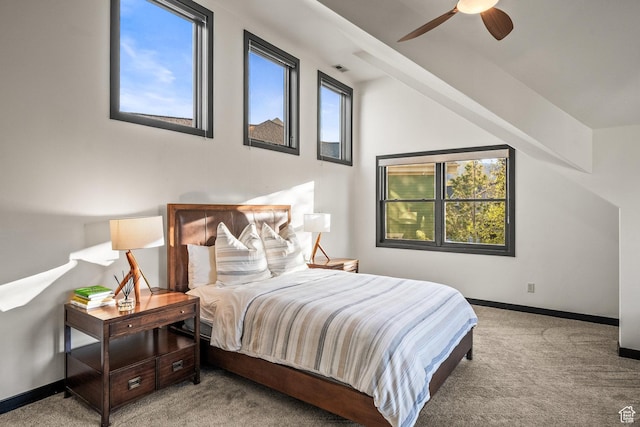 bedroom featuring carpet floors, multiple windows, baseboards, a ceiling fan, and vaulted ceiling