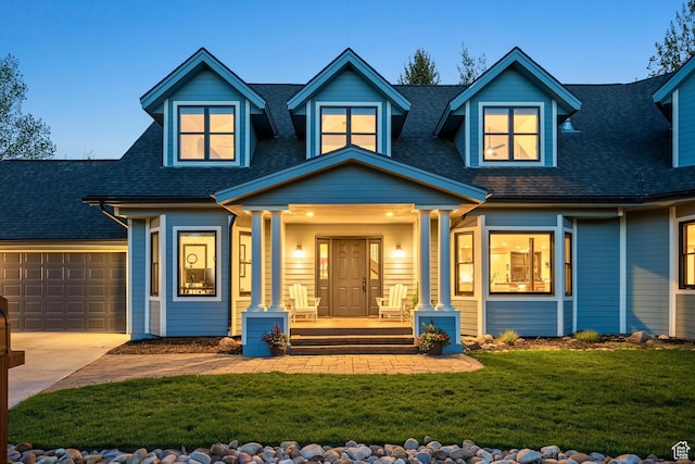 view of front of property featuring a porch, driveway, a shingled roof, and a front yard