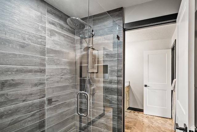 bathroom featuring a shower stall, vanity, and marble finish flooring