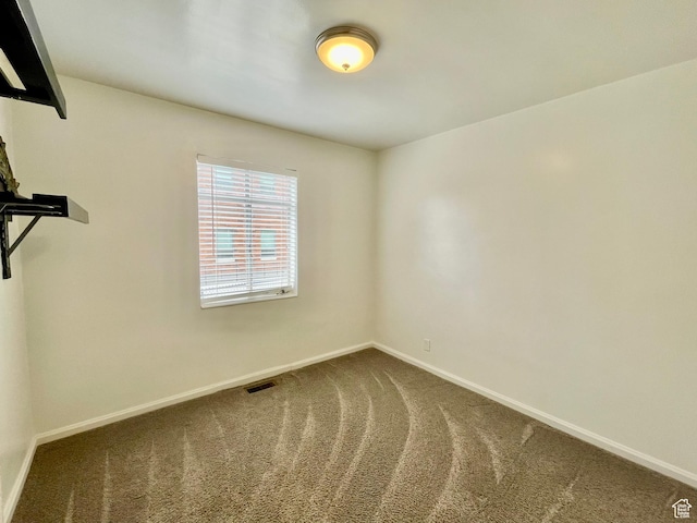 empty room featuring baseboards and carpet floors