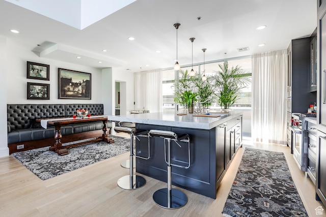 268 S State St E Unit 417, Salt Lake City, UT 84111 - kitchen with a sink, a kitchen island, light wood-style flooring, recessed lighting, and a breakfast bar area