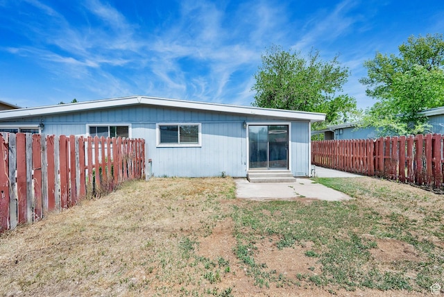 rear view of house with a fenced backyard