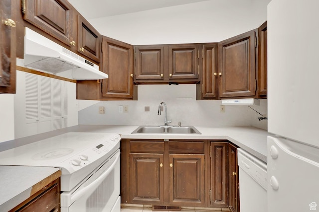 kitchen with white appliances, a sink, under cabinet range hood, light countertops, and tasteful backsplash
