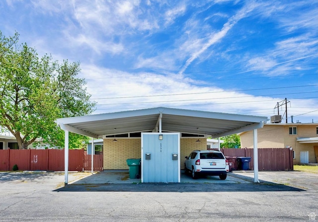 view of vehicle parking with fence