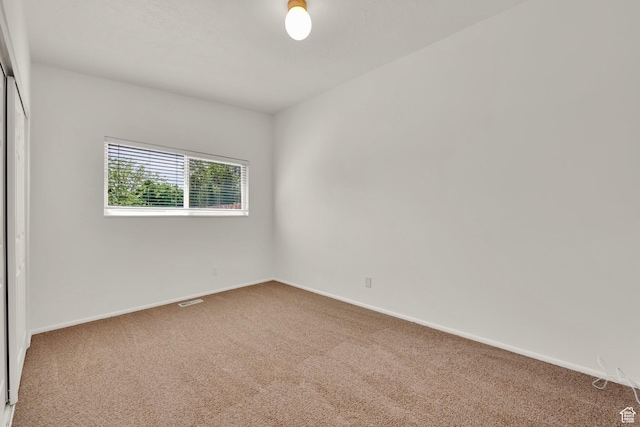 unfurnished room with carpet floors and baseboards