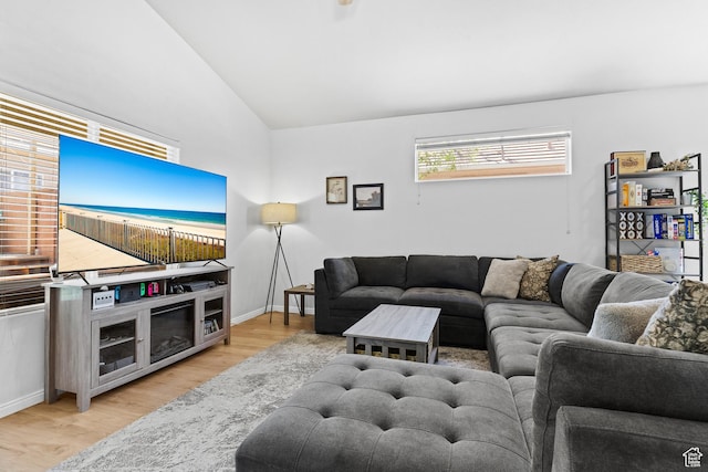 living room featuring vaulted ceiling, wood finished floors, and baseboards