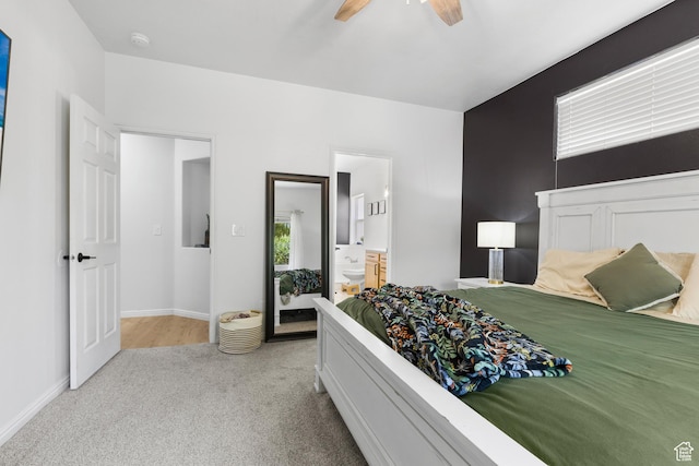 carpeted bedroom featuring baseboards, ceiling fan, and ensuite bath